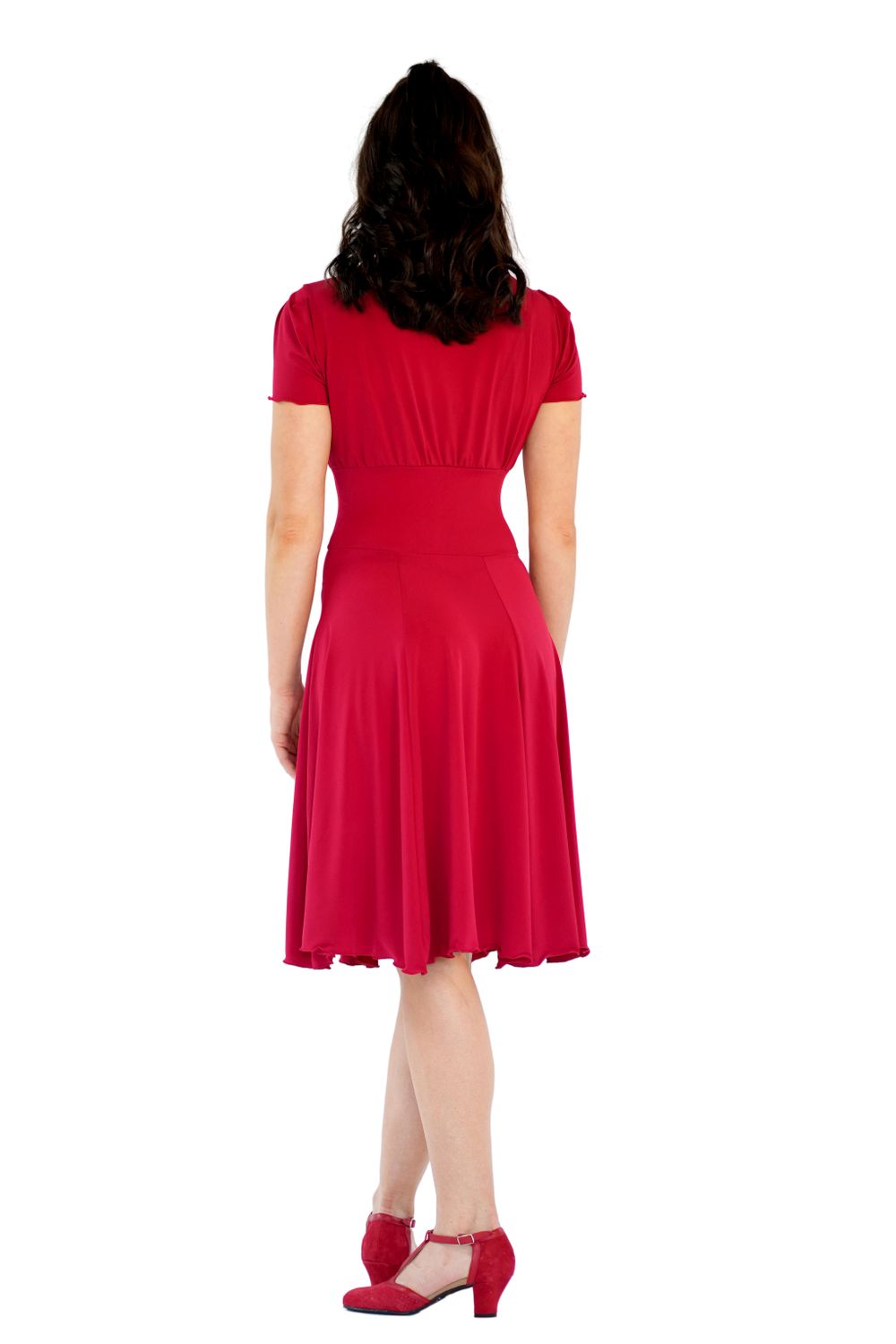 Frau in einem RU5751 Augusta Kurzarm-Kleid von Rumpf, rotem Kleid und Schuhen, steht mit dem Rücken zu ihr.